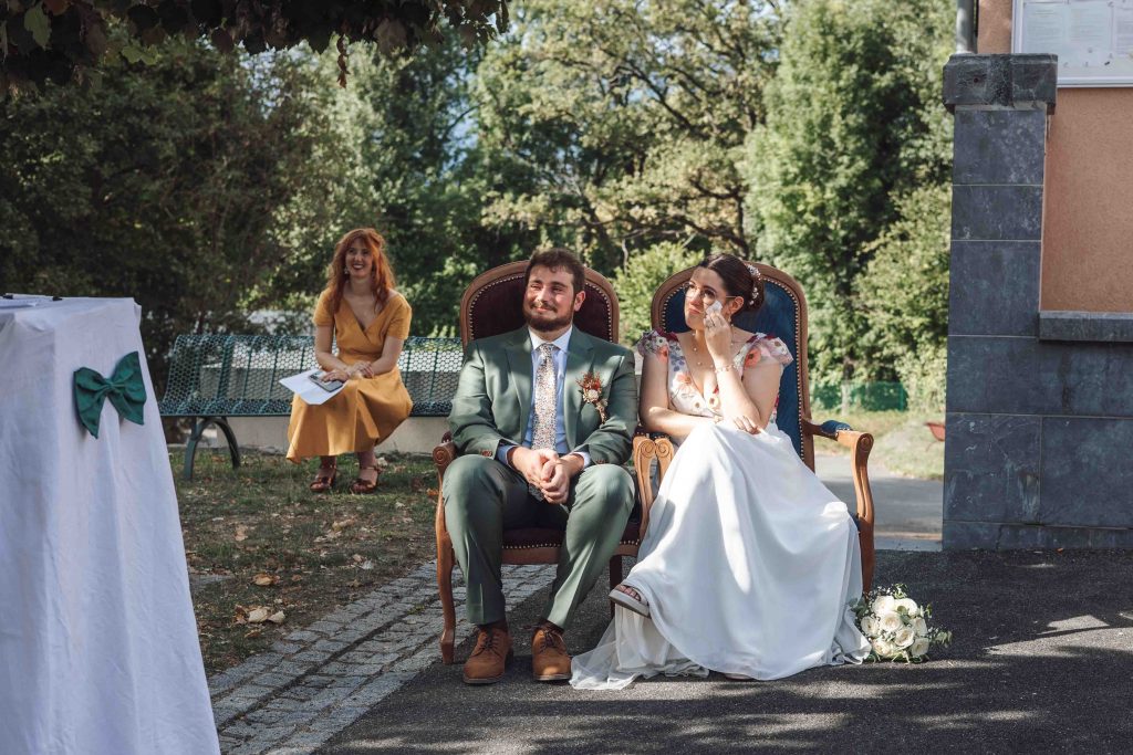 Photographe mariage Sud-Ouest capture l’émotion des mariés Marine et Bastien écoutant les témoignages de leurs proches à Beaucens, Pyrénées, mariage en extérieur, photographe de mariage Toulouse, Pau, Biarritz, landes, photo de mariage authentique et naturelle.