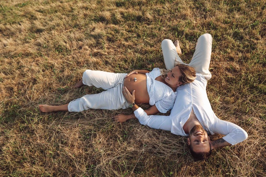 Séance grosssesse à Lourdes en couple dans les champs au couché du soleil